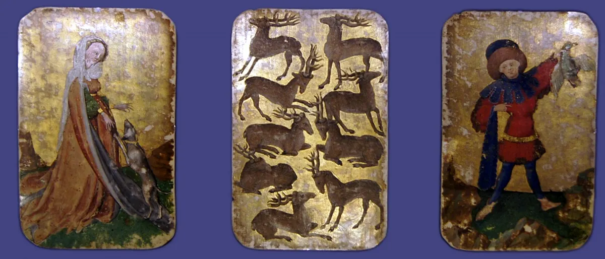 Three gold-backed painted cards from about 1430 showing a woman with a dog, nine stags, and a man holding a bird.